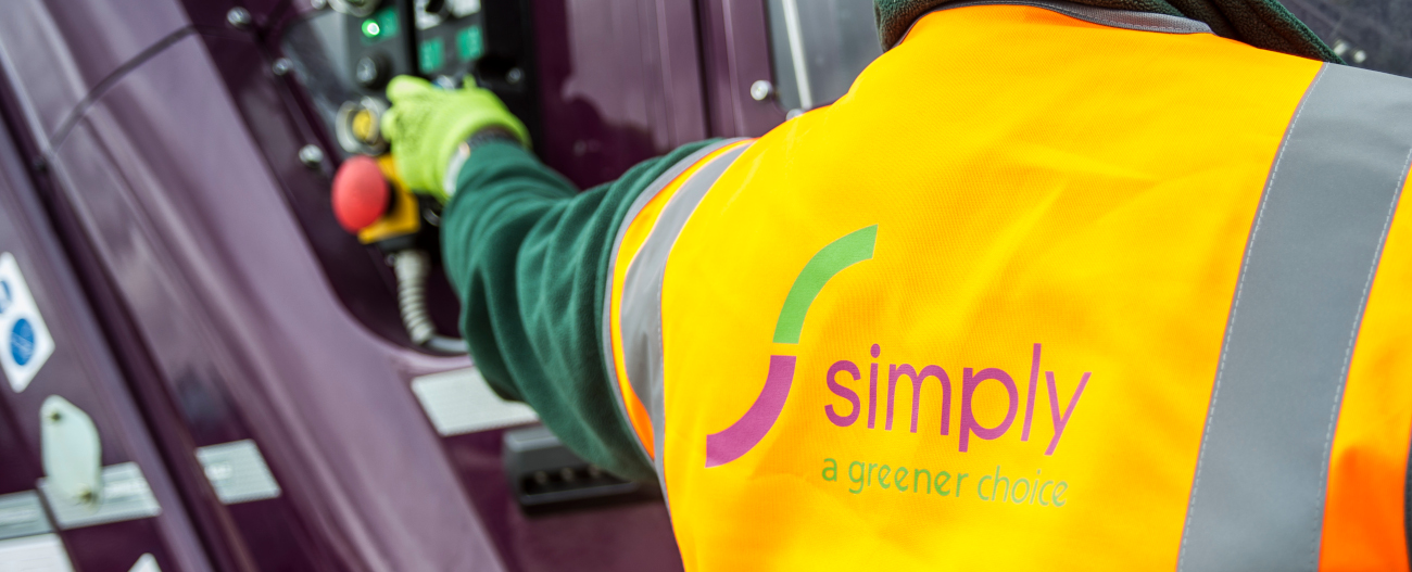 Simply Waste Solutions driver in high visibility jacket pressing bin lift button on truck